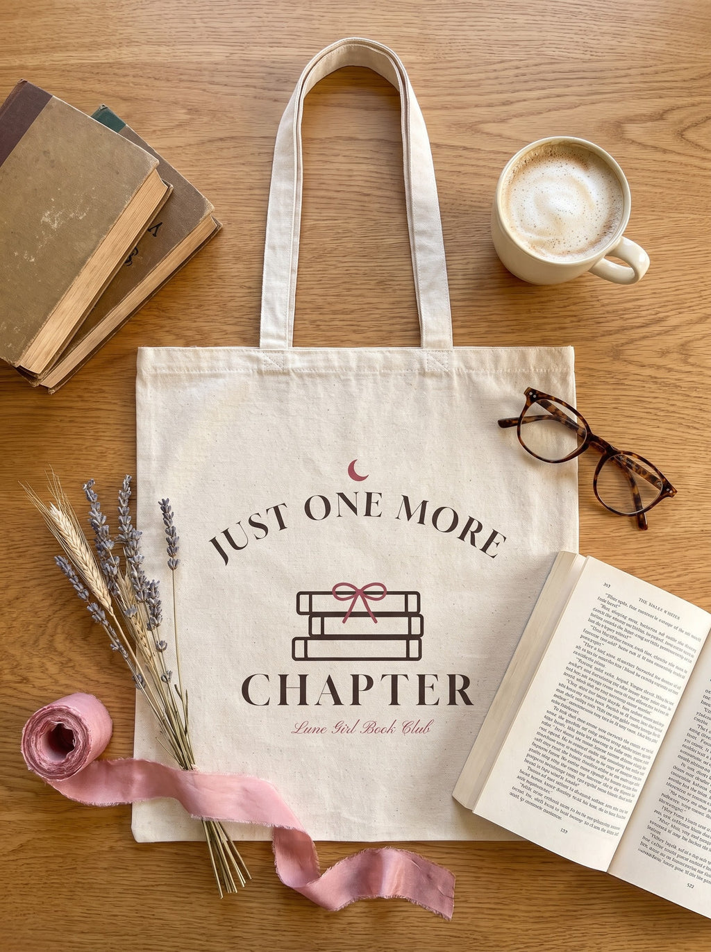 Just One More Chapter book club canvas tote flat lay with vintage books, latte and reading glasses