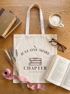 Just One More Chapter book club canvas tote flat lay with vintage books, latte and reading glasses