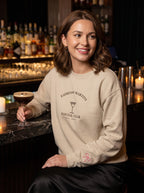 Smiling woman holding an espresso martini in the sand Espresso Martini Social Club sweatshirt