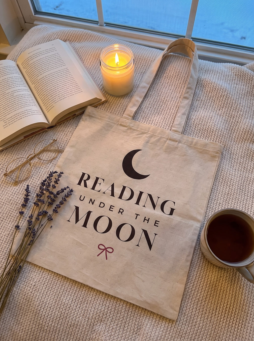 Cozy evening flat lay of the Reading Under the Moon tote on a knit blanket by the window