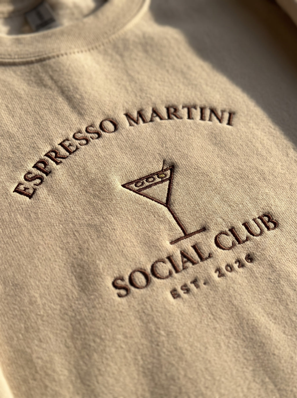 Macro of the raised satin-stitch lettering on the Espresso Martini Social Club crewneck