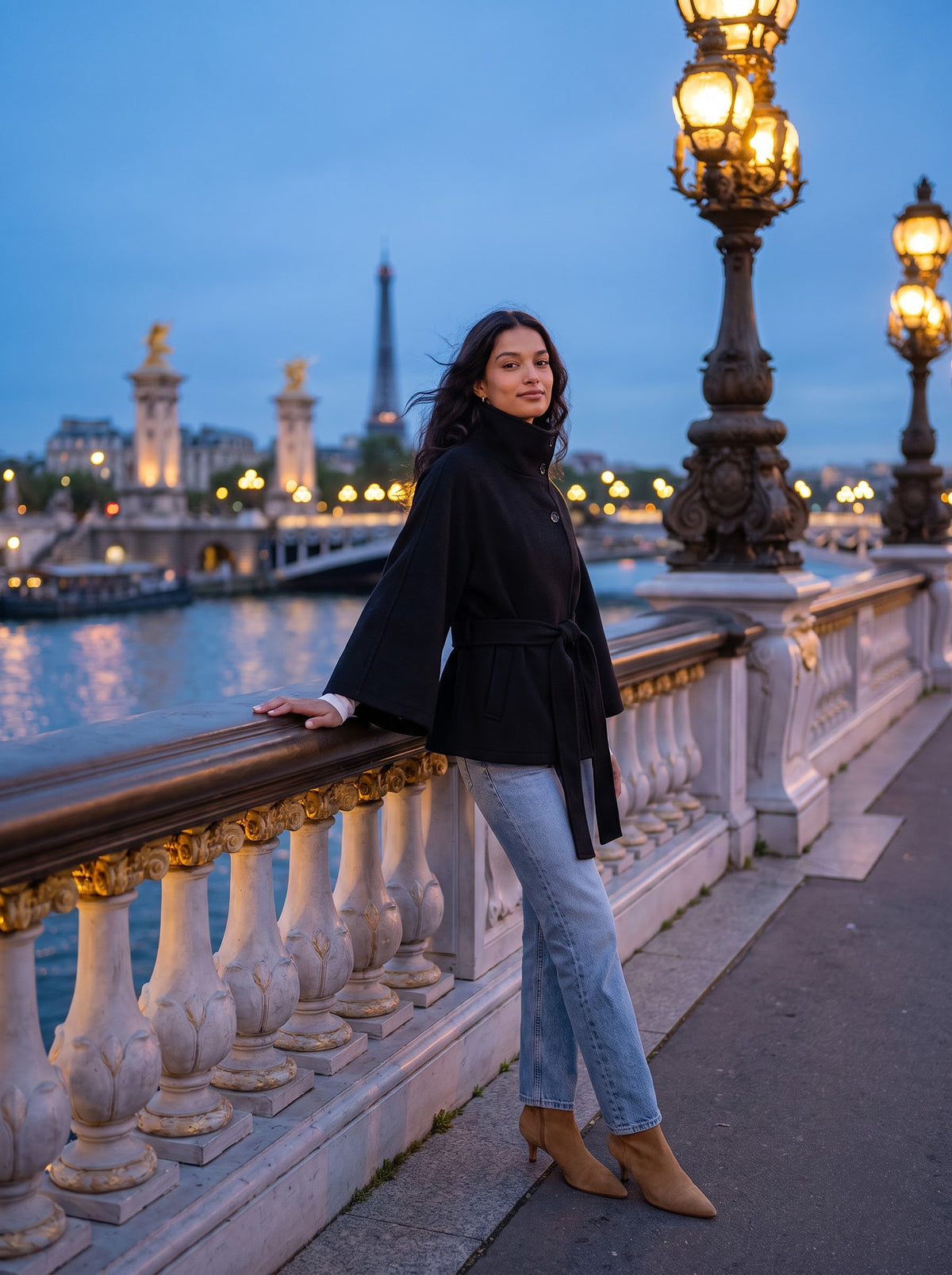 Woman in the black City Muse cape coat on the Pont Alexandre III bridge in Paris at dusk with glowing lamps