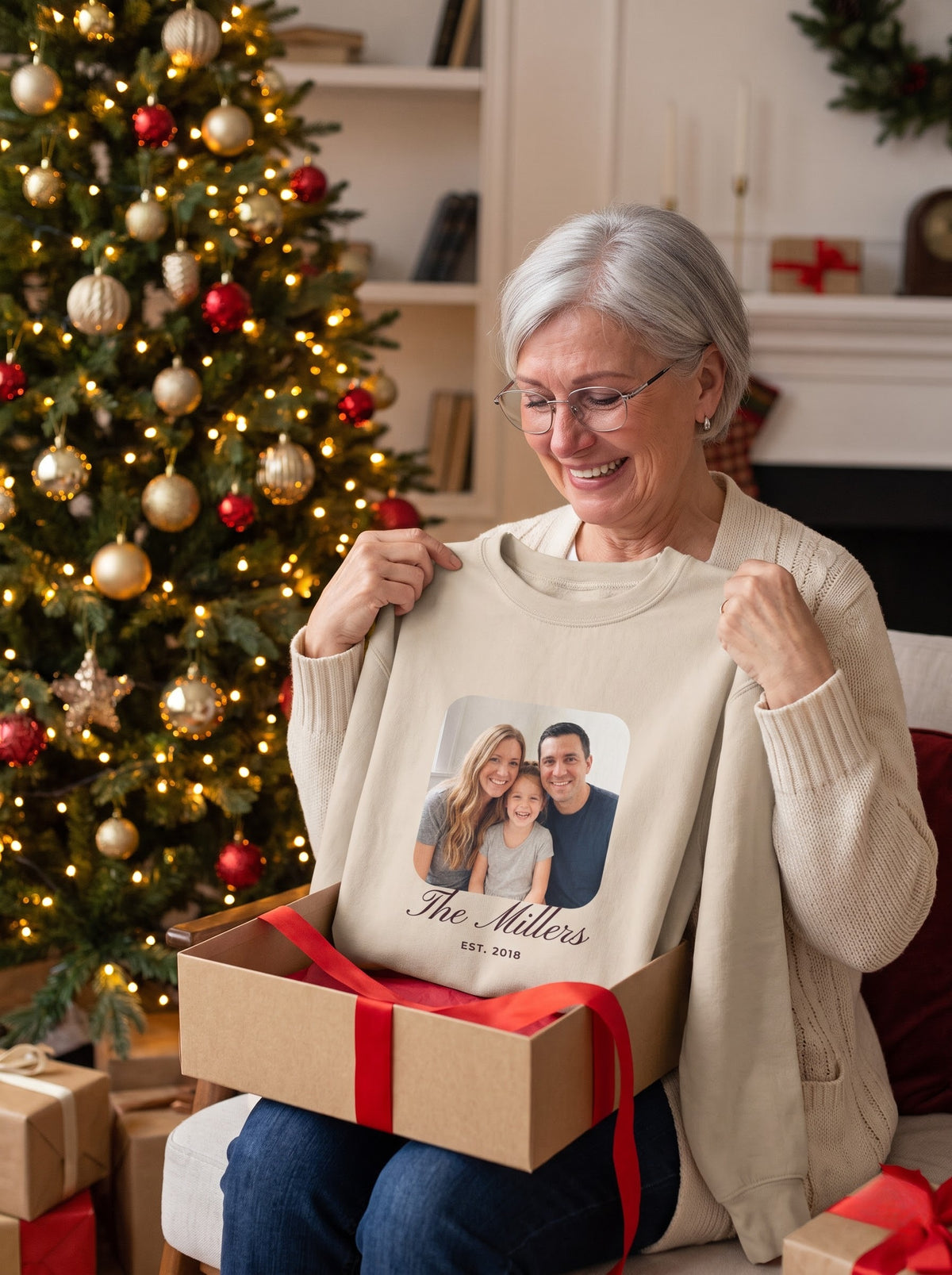 Grandmother opening a Christmas gift with a sand custom family photo crewneck sweatshirt