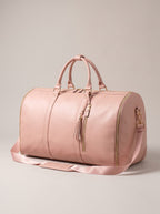 Getaway foldable garment duffle bag in blush pink faux leather with gold zippers and shoulder strap