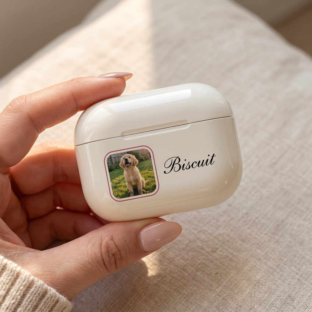 Close-up of a cream custom AirPods Pro 3 case with a rose-framed puppy photo and the name Biscuit in script