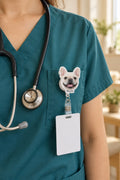 Retractable badge reel with a French bulldog photo cut to shape and the name Mochi, clipped to a nurse's scrubs pocket