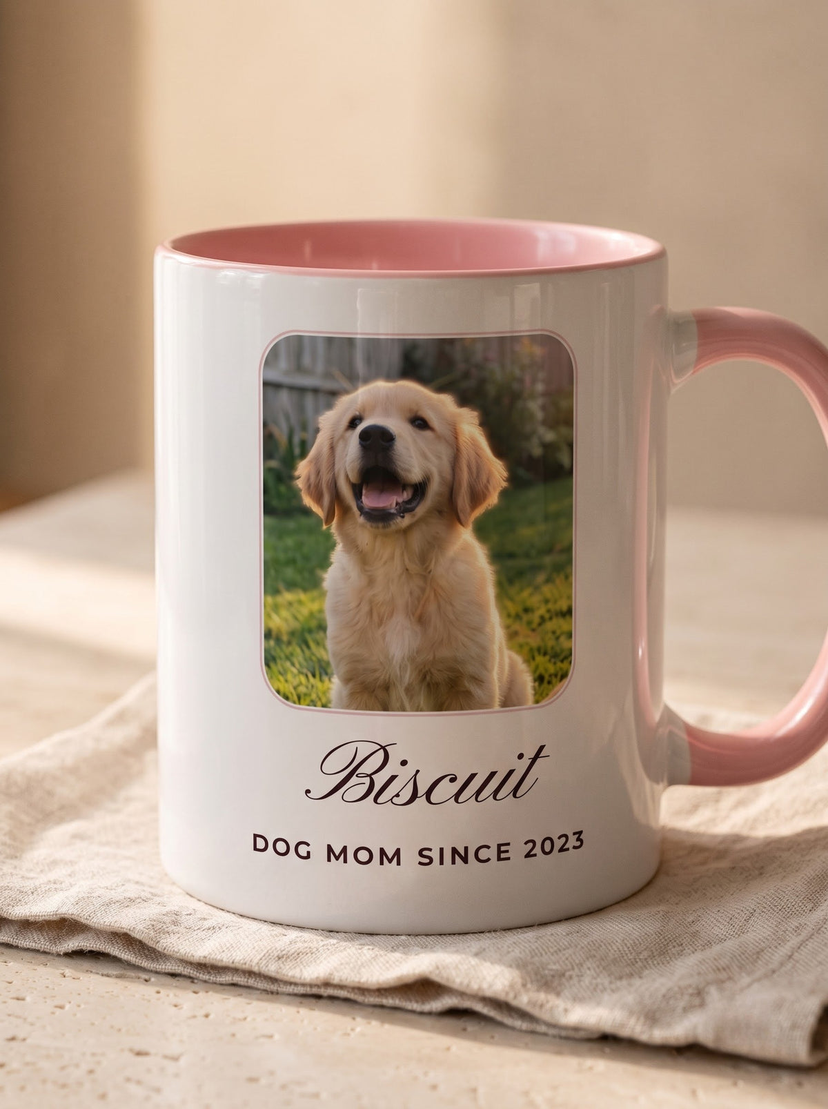 Close-up of the printed pet photo and name Biscuit – Dog Mom Since 2023 on a pink-handled ceramic mug