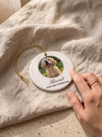 Close-up of a ceramic pet photo ornament with name Biscuit and Our First Christmas on linen