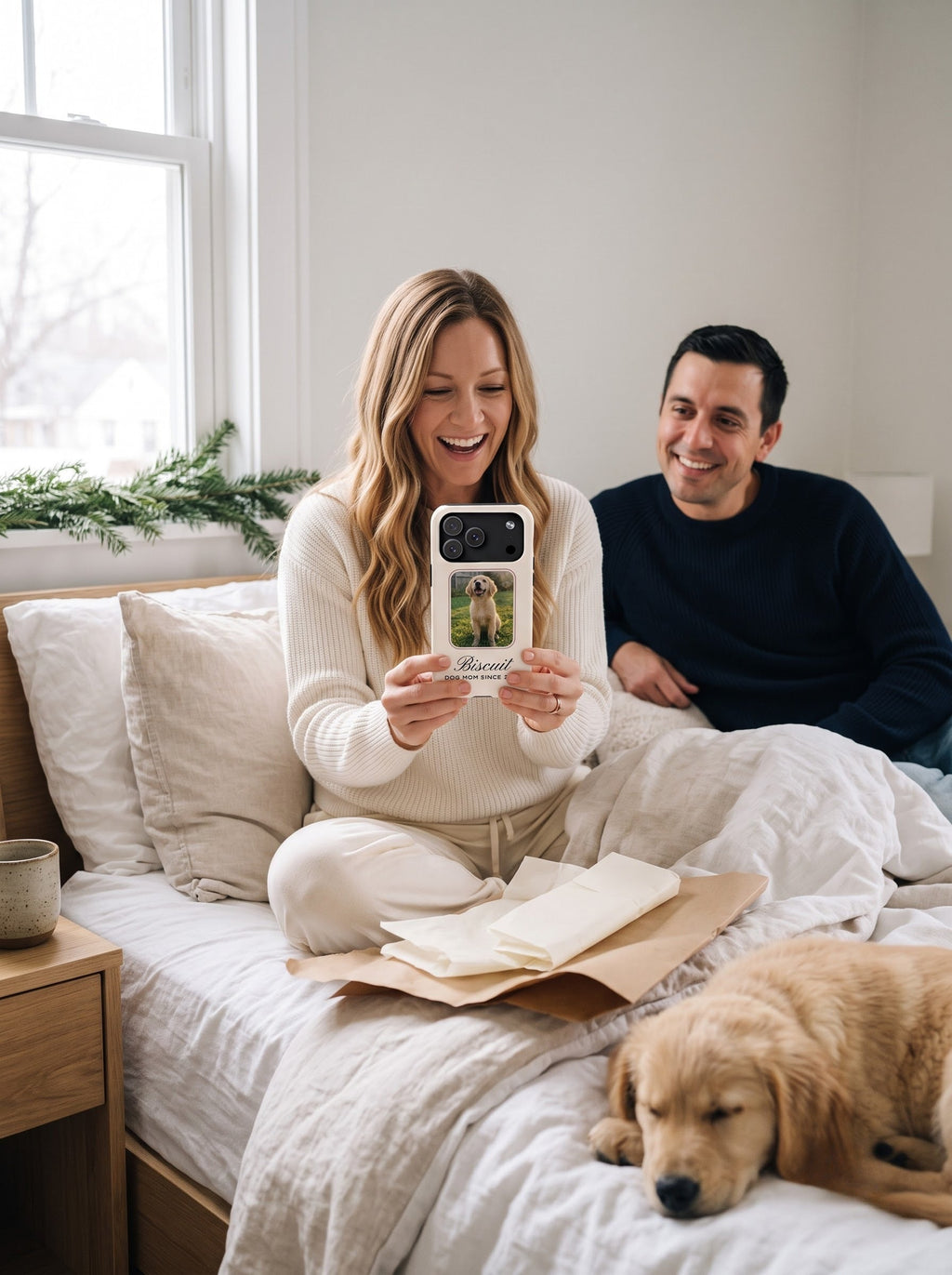 Couple opening a personalized dog photo phone case on Christmas morning in bed
