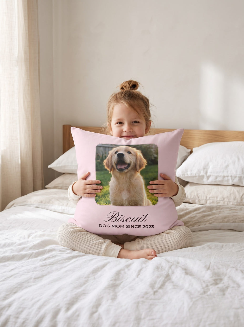 Little girl hugging a custom puppy photo pillow on a white linen bed