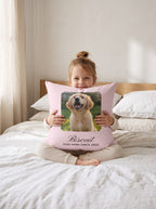 Little girl hugging a custom puppy photo pillow on a white linen bed