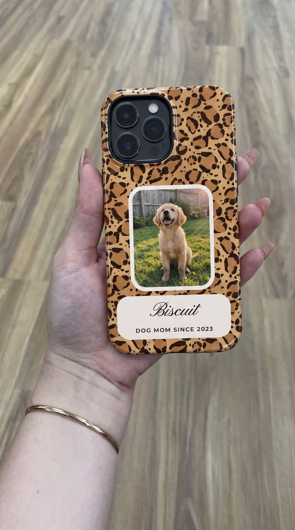 Leopard full-wrap MagSafe tough case with a puppy photo window and name plate, held flat in hand