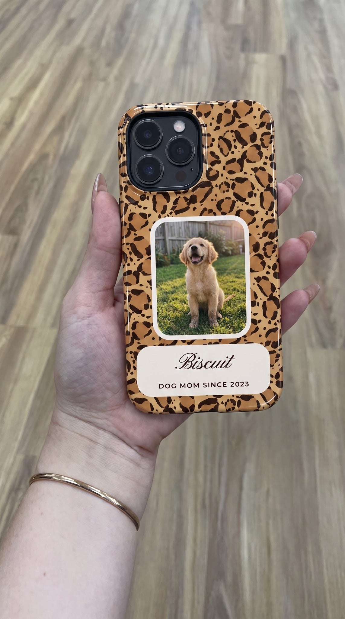 Leopard full-wrap MagSafe tough case with a puppy photo window and name plate, held flat in hand