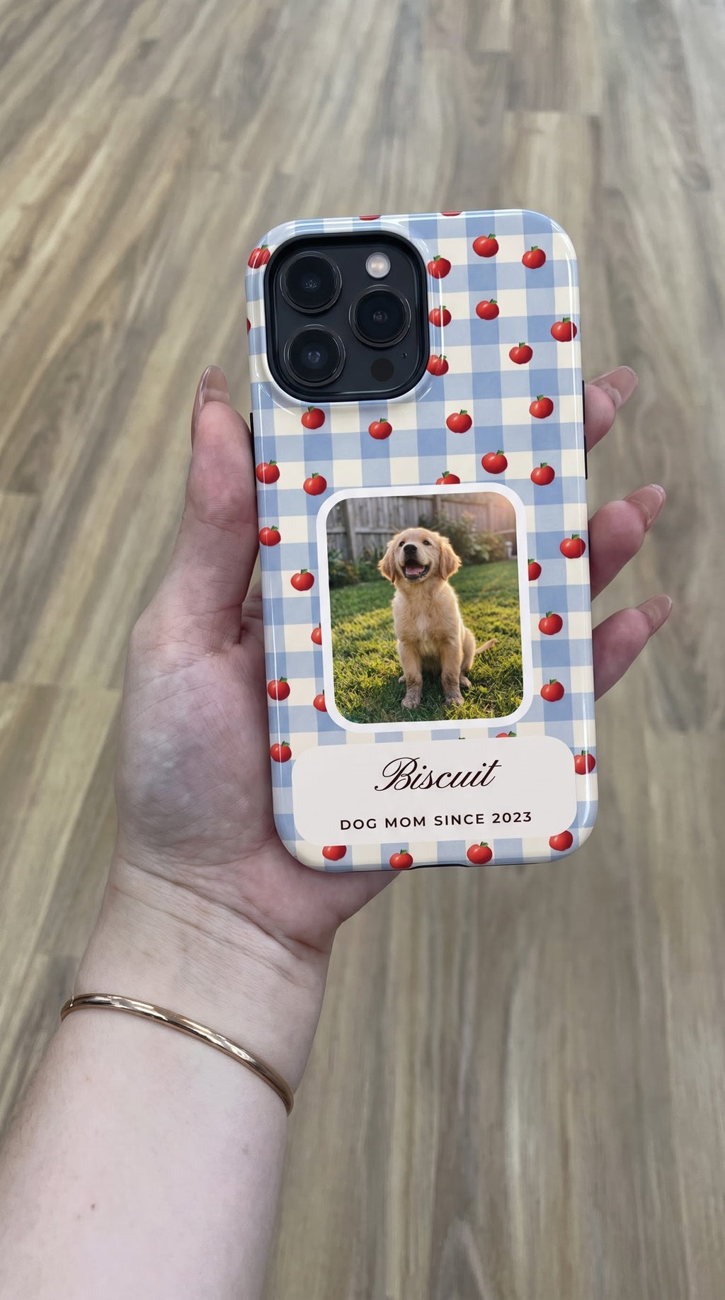 Blue gingham with red apples full-wrap case with a puppy photo window, held in hand