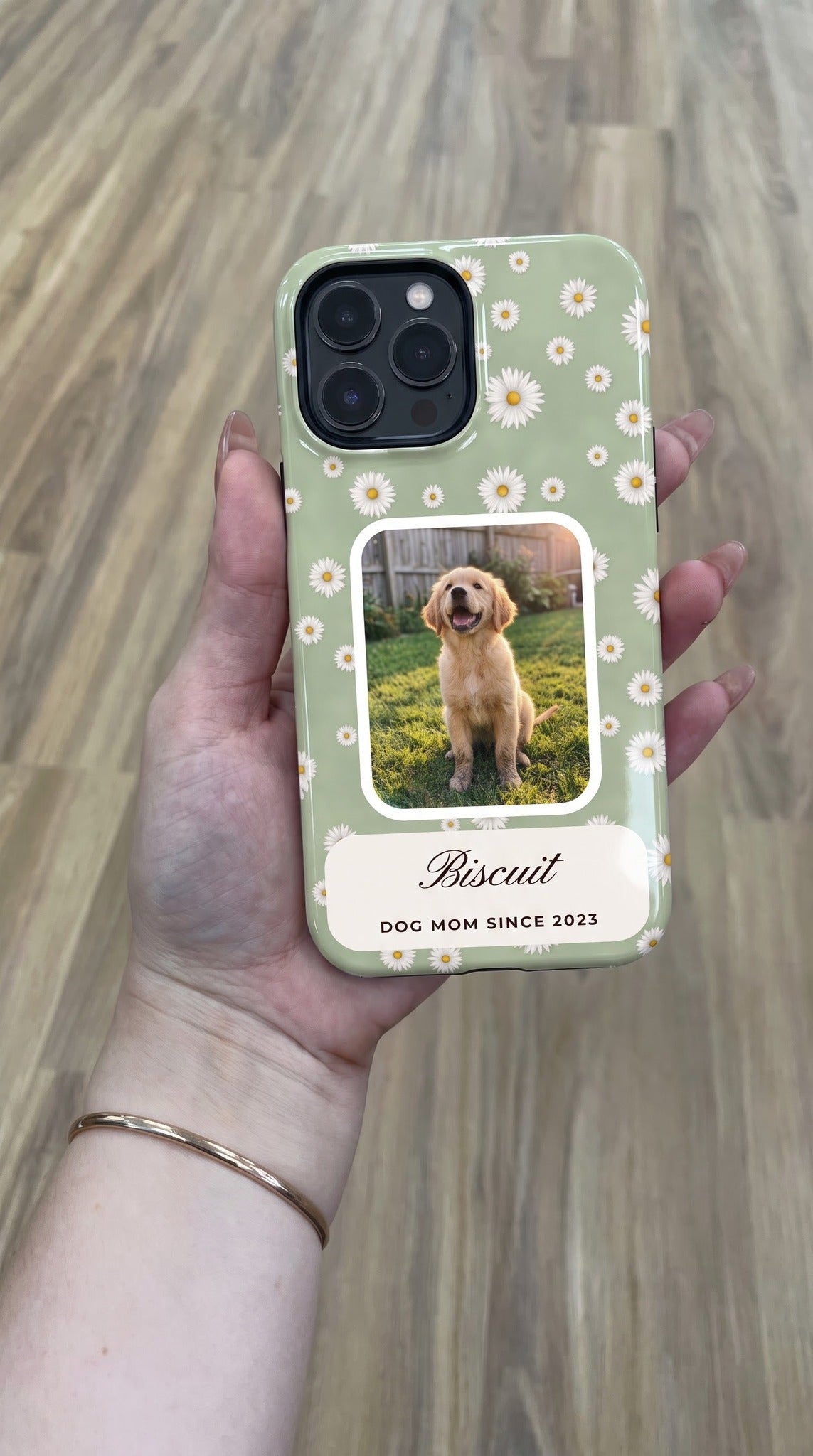 Sage daisy full-wrap case with a puppy photo window, held in hand