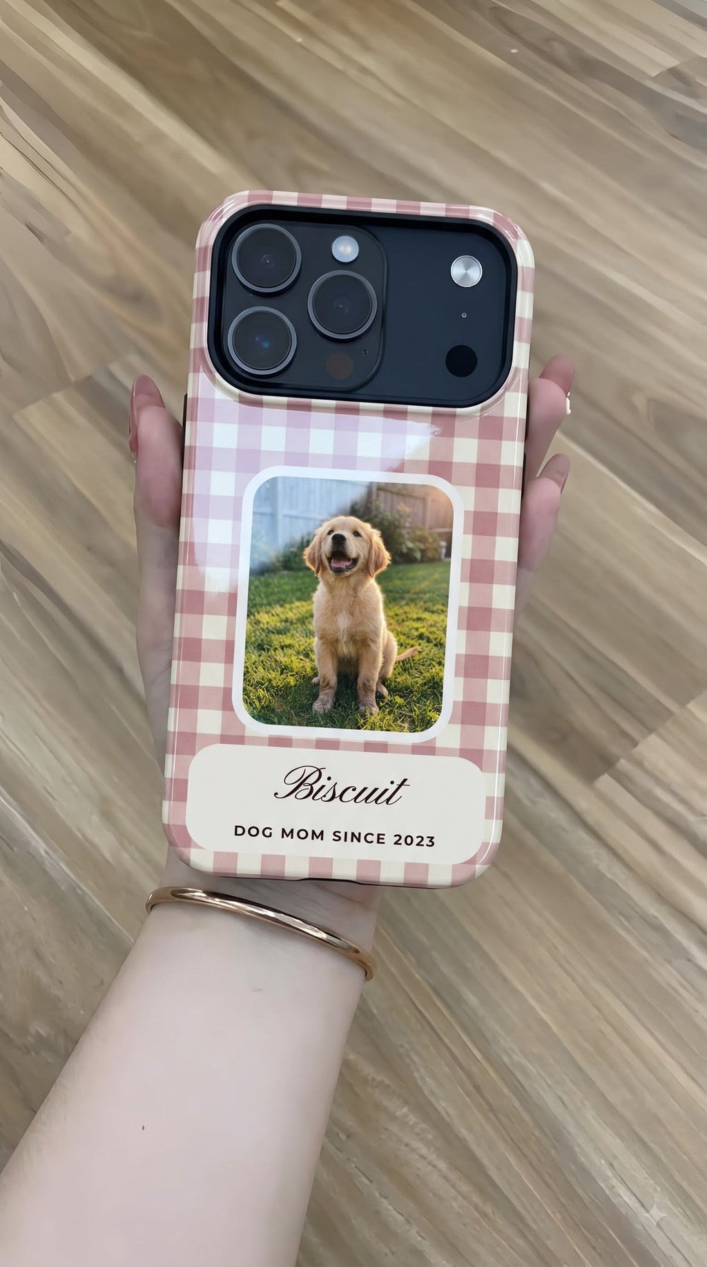 Rose gingham full-wrap MagSafe tough case with a puppy photo window and the name Biscuit, held flat in hand
