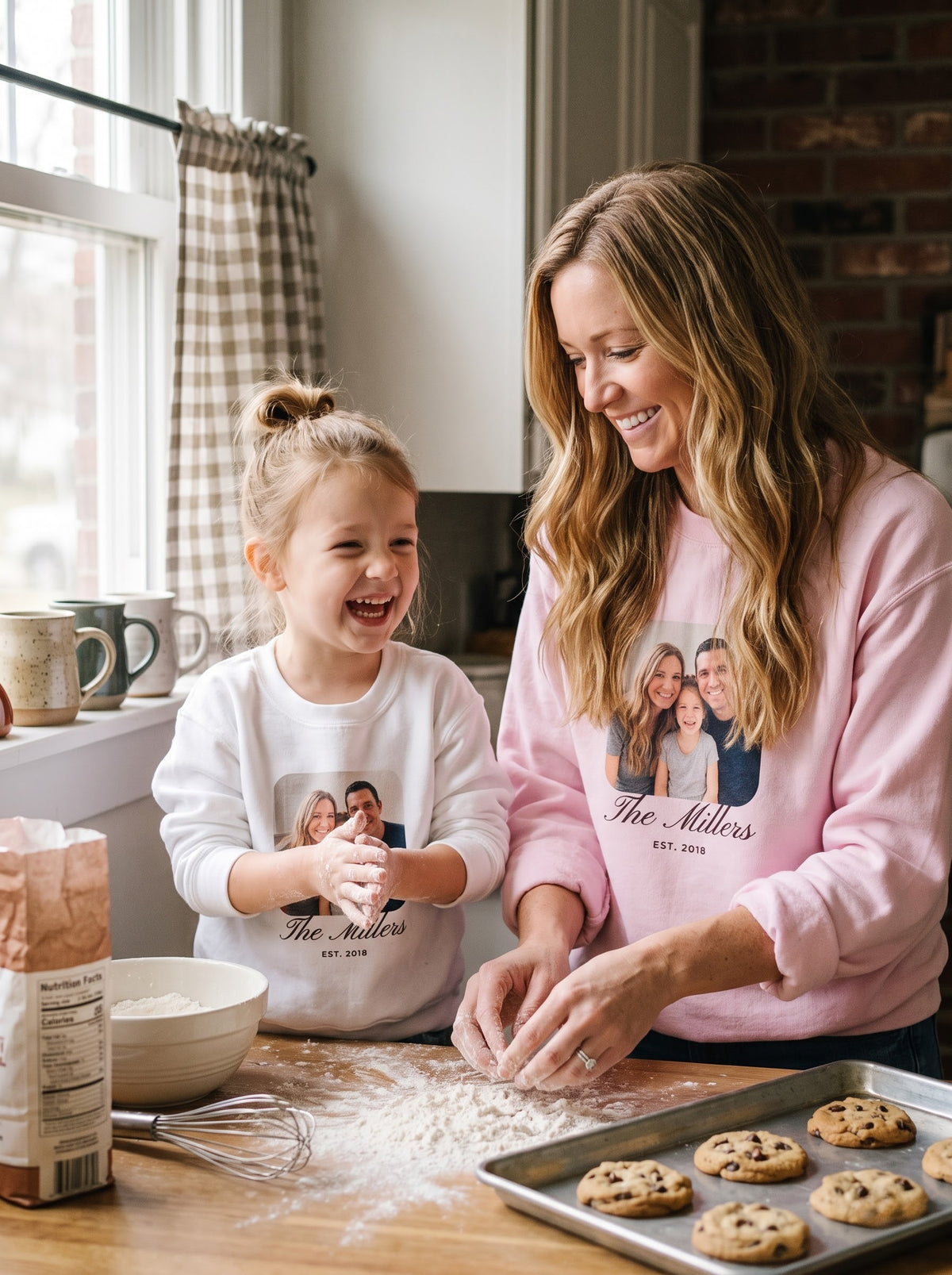 Mom and daughter baking cookies in matching custom family photo sweatshirts in light pink and white